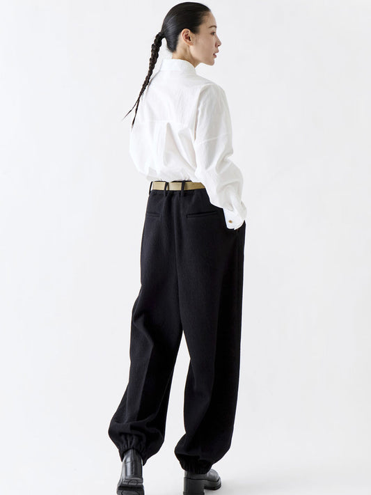 Soh rear three-quarter view of white shirt tucked into black trousers