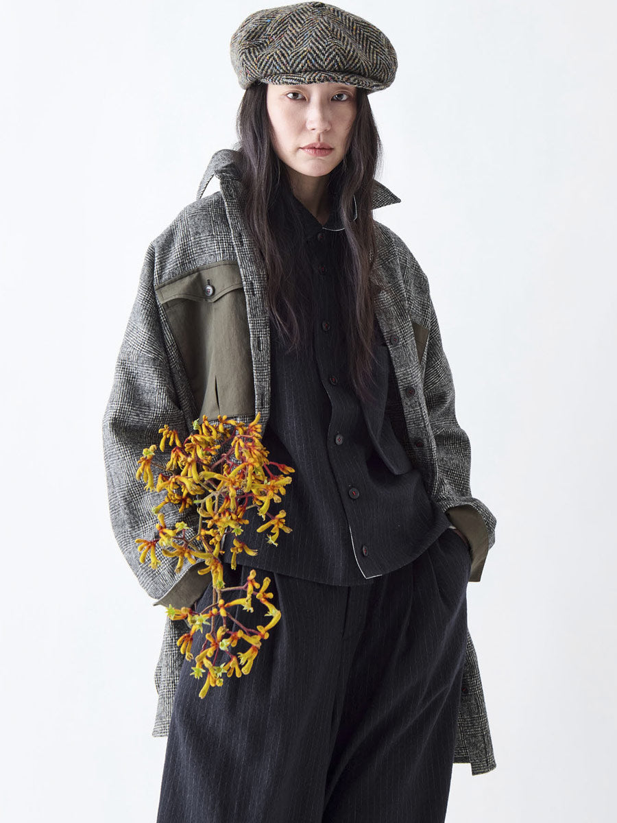 Soh three-quarter view of long check coat with khaki contrast panel
