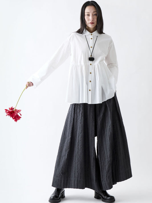 Soh full-length styling view of white gathered shirt worn over dark wide trousers