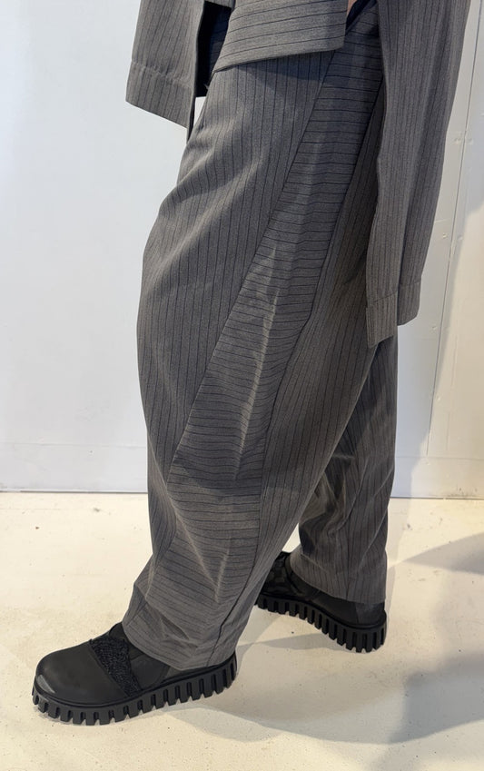 Side view of the Calla trousers showing a pocket and a panel with horizontal pinstripes