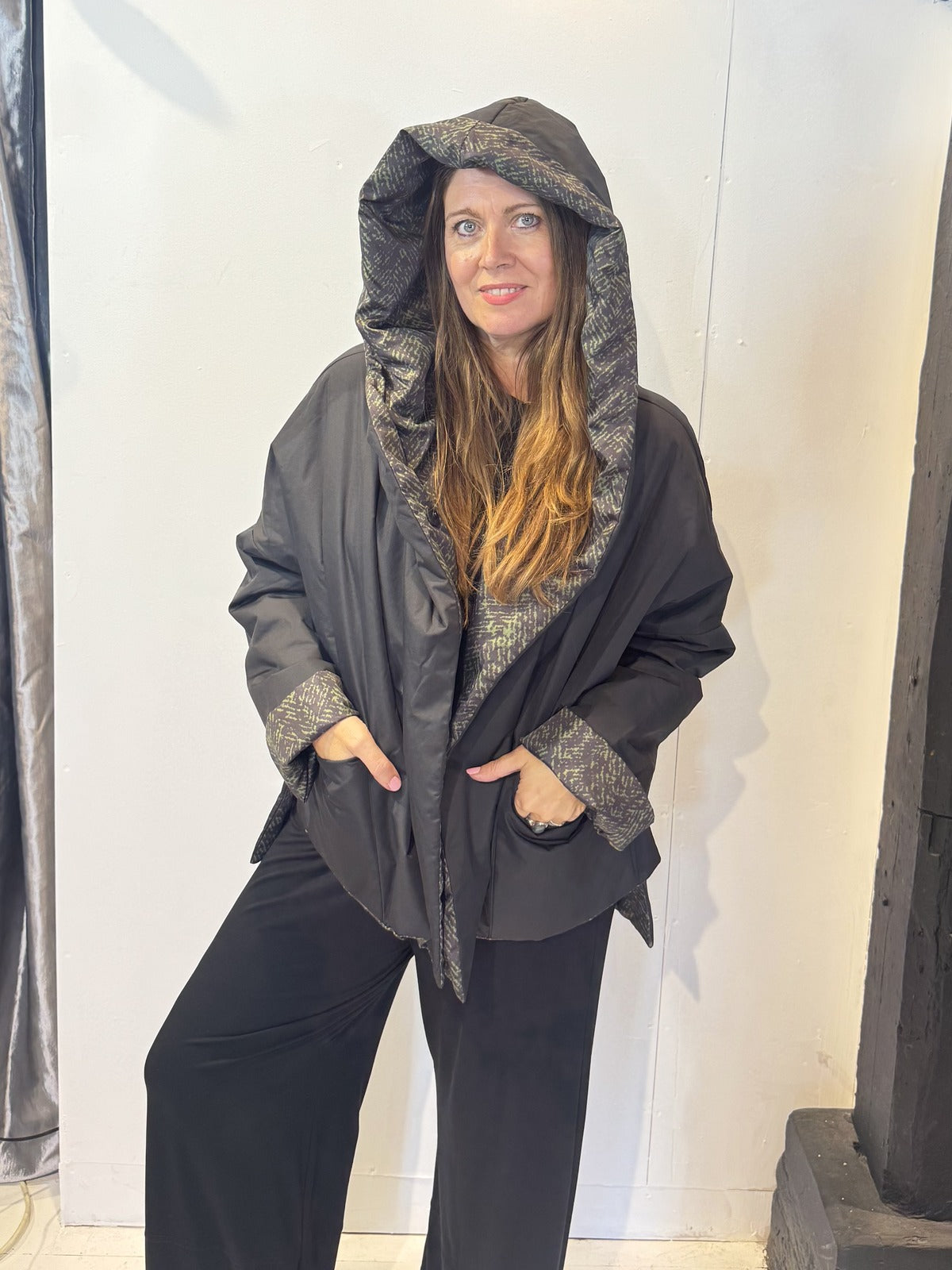 Igor Dobranic Hibiscus reversible jacket: plain black front with hood up and patterned reverse visible