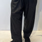 Front view of the Igor Dobranic Ivy dark grey trousers showing their rounded legs and side pockets