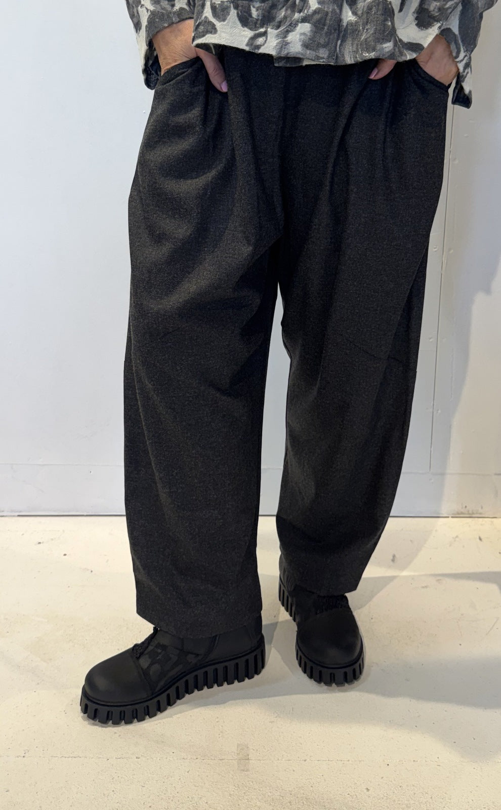 Front view of the Igor Dobranic Ivy dark grey trousers showing their rounded legs and side pockets