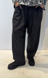 Front view of the Igor Dobranic Ivy dark grey trousers showing their rounded legs and side pockets