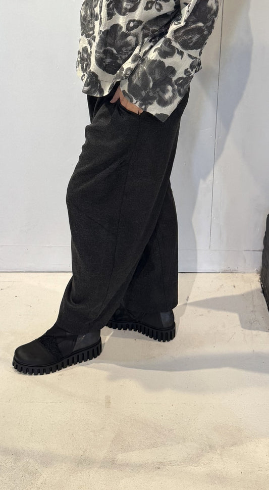 Side view of the Ivy trousers showing their sculptural shape and ankle-length hem