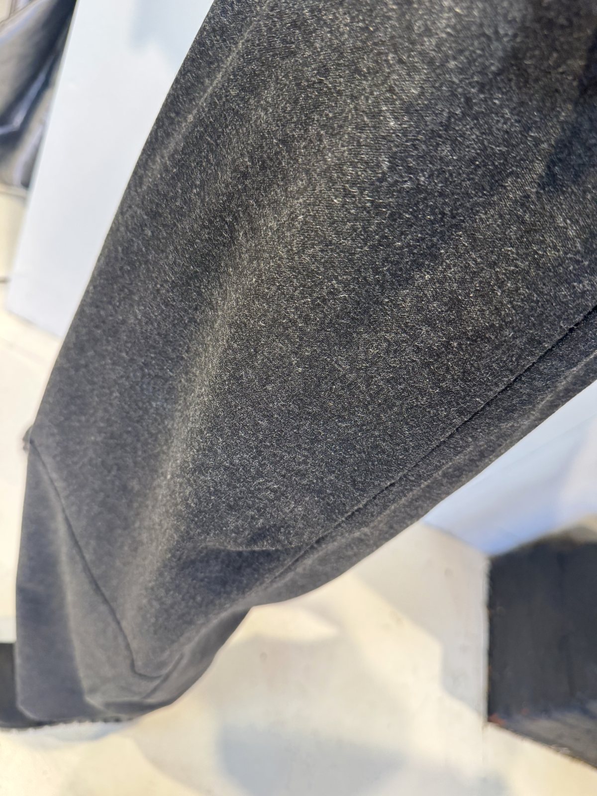 Close-up of the Ivy trousers showing the fine mottled grey fabric