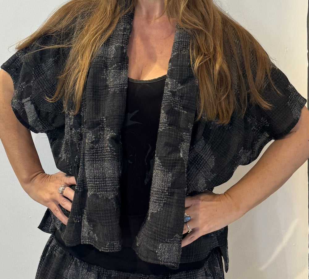 Detail of the Lotus waistcoat showing its textured checked weave and broad front edge