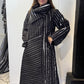 Igor Dobranic Magnolia coat buttoned up, with its large collar wrapped around the neckline