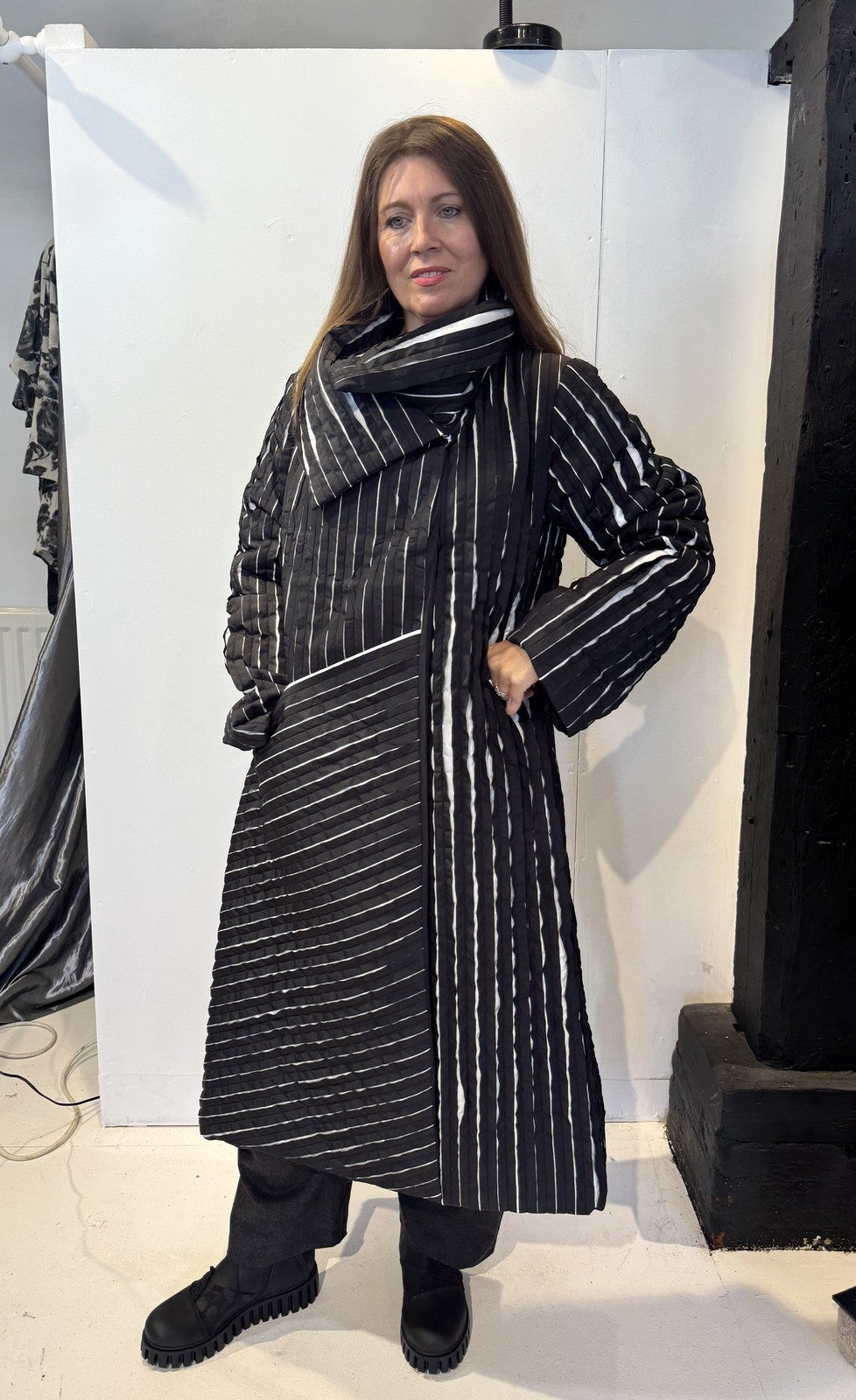 Igor Dobranic Magnolia coat buttoned up, with its large collar wrapped around the neckline