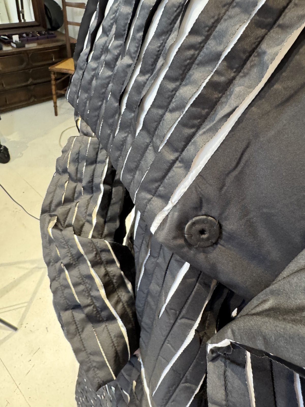 Close-up of the Magnolia coat showing its covered button and raised striped texture