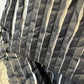 Detail of the Magnolia coat showing rippled black fabric and narrow white stripes
