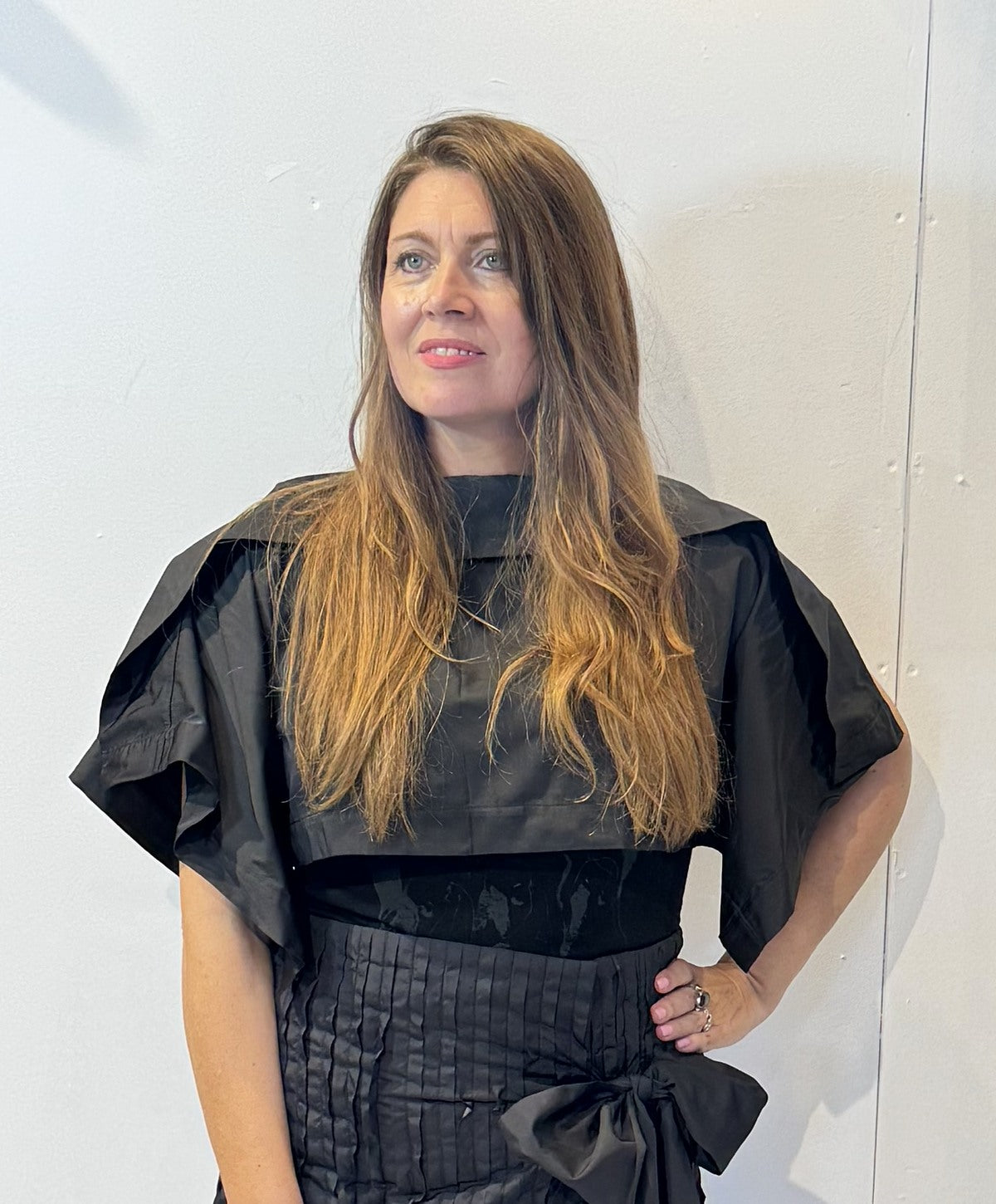 Front view of the Igor Dobranic May black bolero showing its cropped body and folded shoulder panels