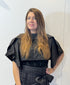 Front view of the Igor Dobranic May black bolero showing its cropped body and folded shoulder panels