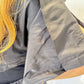 Close-up of the May bolero showing its smooth black fabric and folded shoulder panel