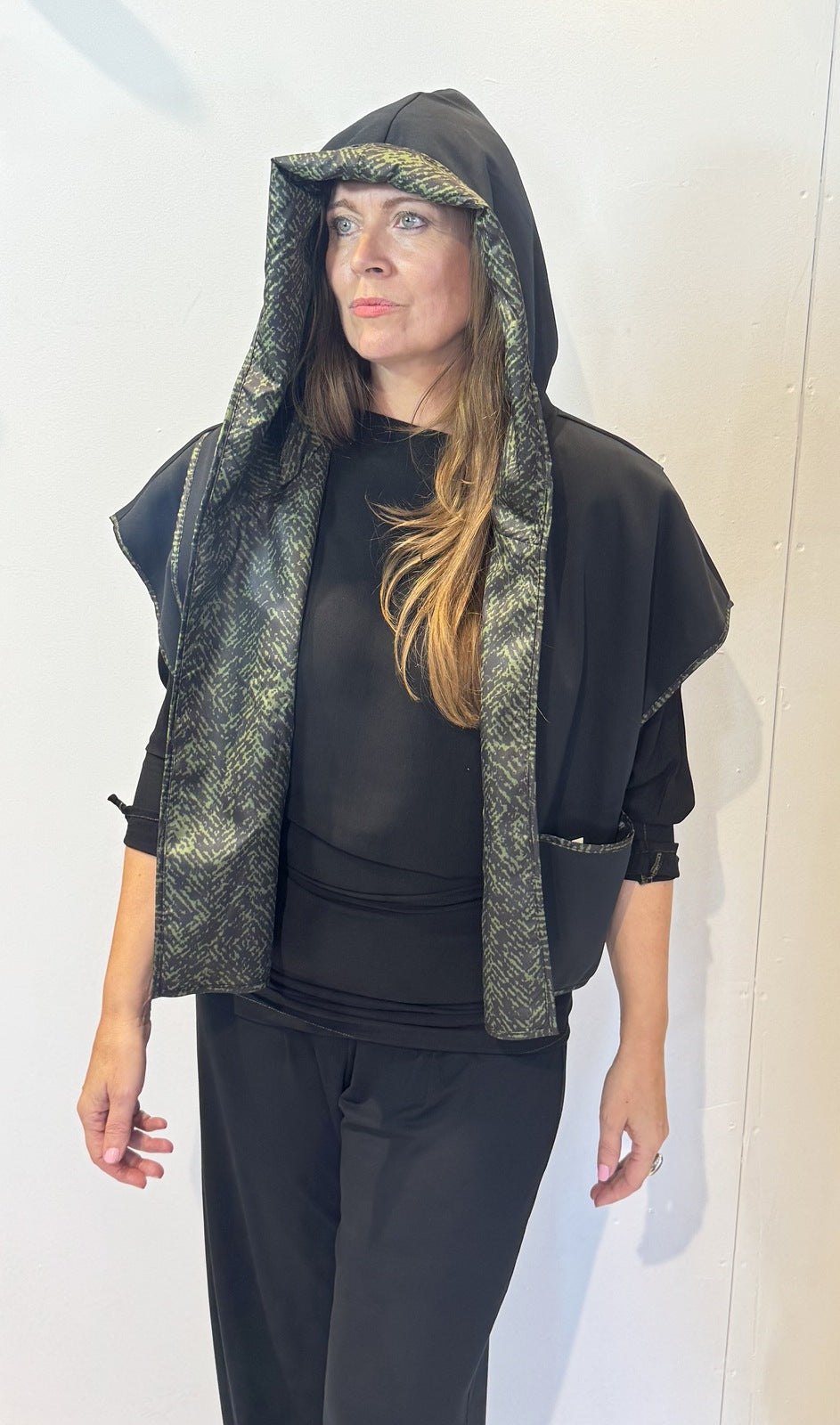 Front view of the Pensy waistcoat on its plain black side with the hood raised