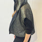 Side view of the Pensy waistcoat showing its patterned side and raised hood