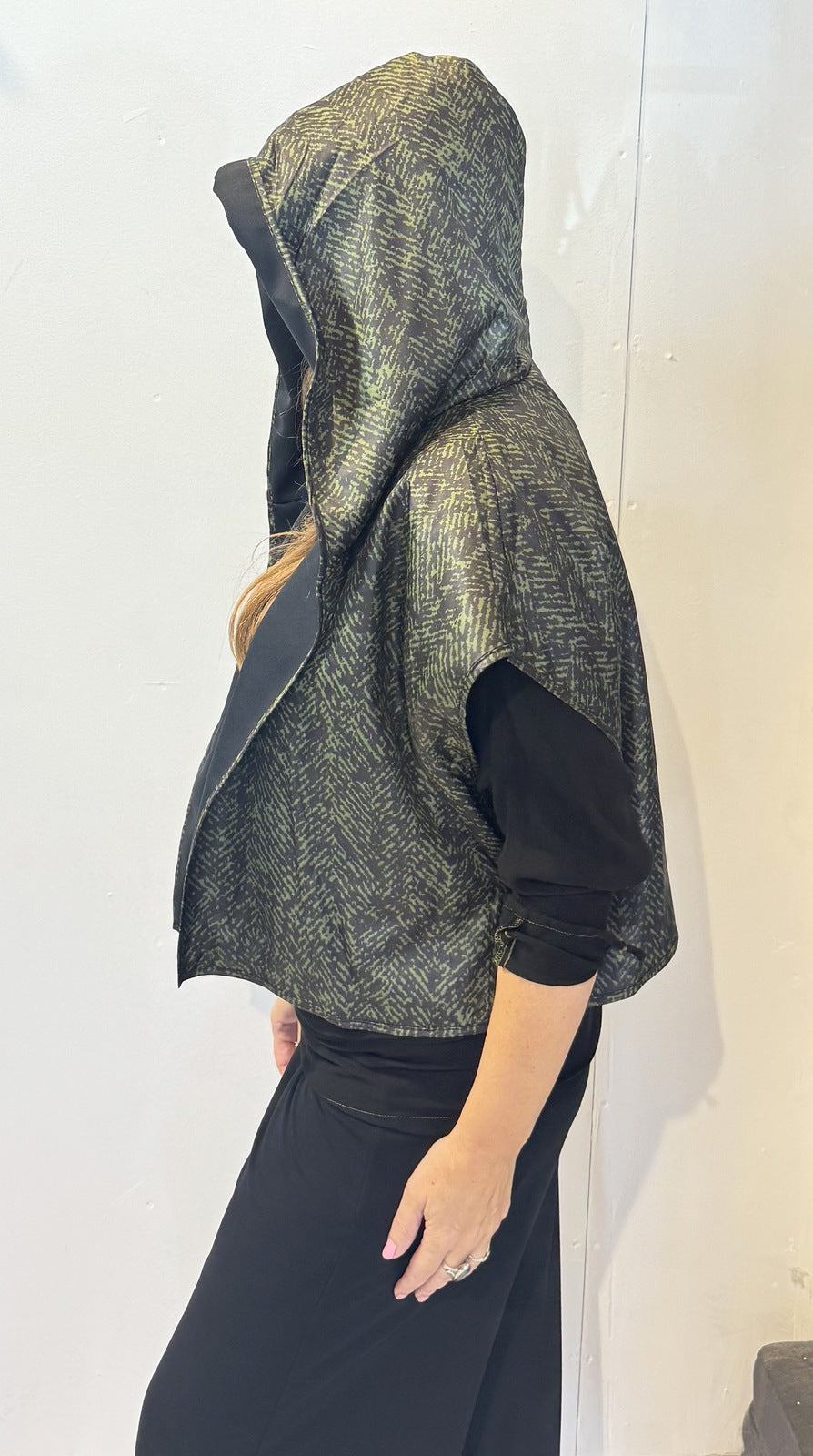 Side view of the Pensy waistcoat showing its patterned side and raised hood