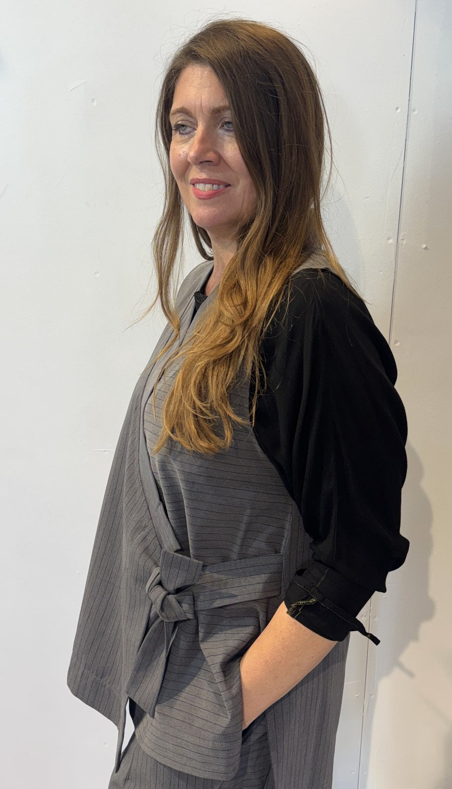 Side view of the Senna waistcoat showing its fabric tie and longer back