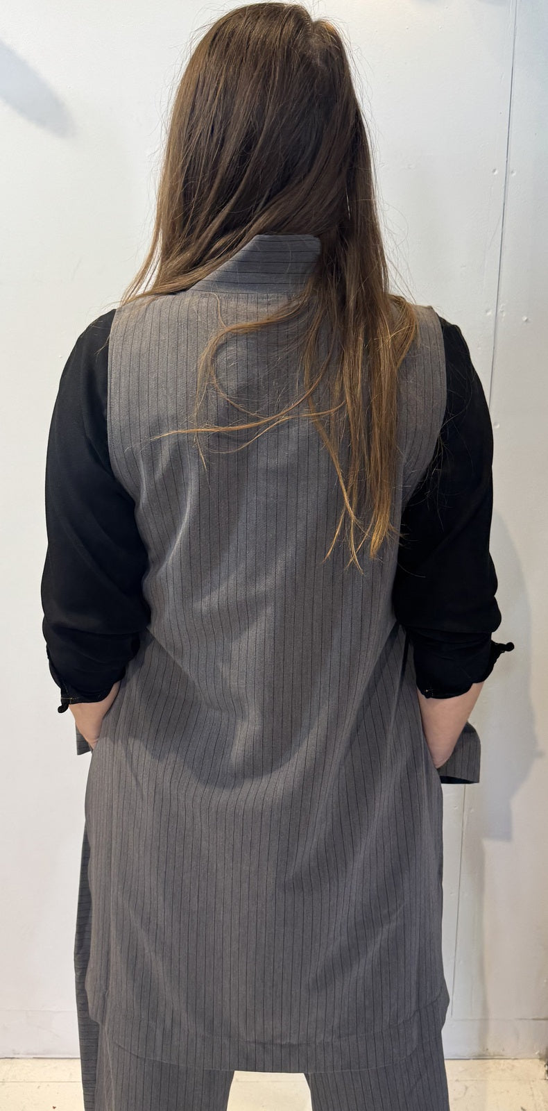 Back view of the Senna grey pinstriped waistcoat showing its long sleeveless silhouette