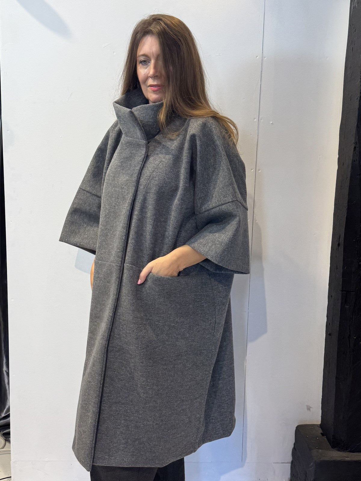 Three-quarter side view of the Sorrel grey coat with wide cropped sleeves