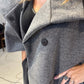 Close-up of the Sorrel coat showing press studs, wide lapels and a curved patch pocket