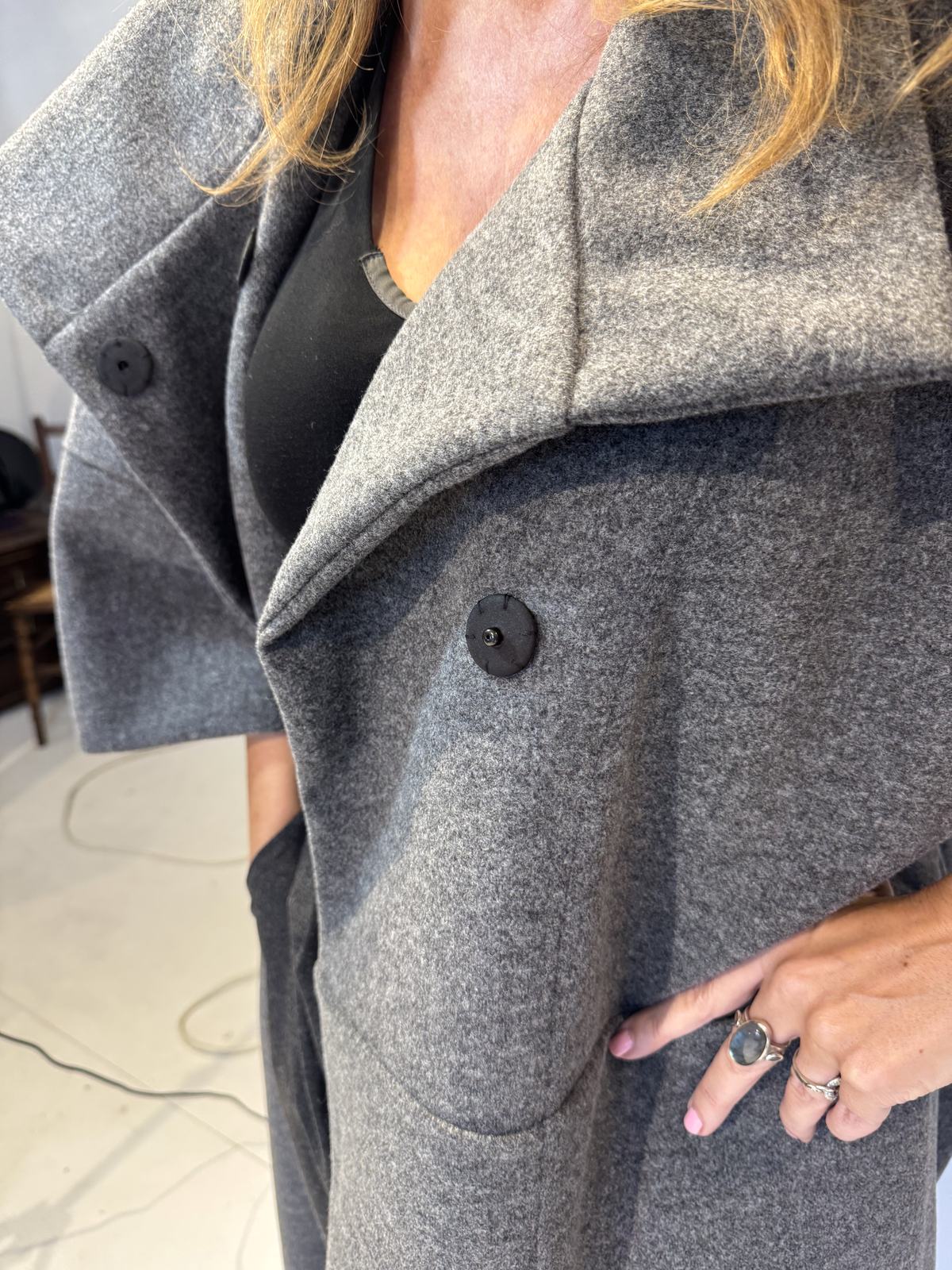 Close-up of the Sorrel coat showing press studs, wide lapels and a curved patch pocket