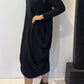 Side view of the Strelizia black dress showing the fabric gathered into soft folds