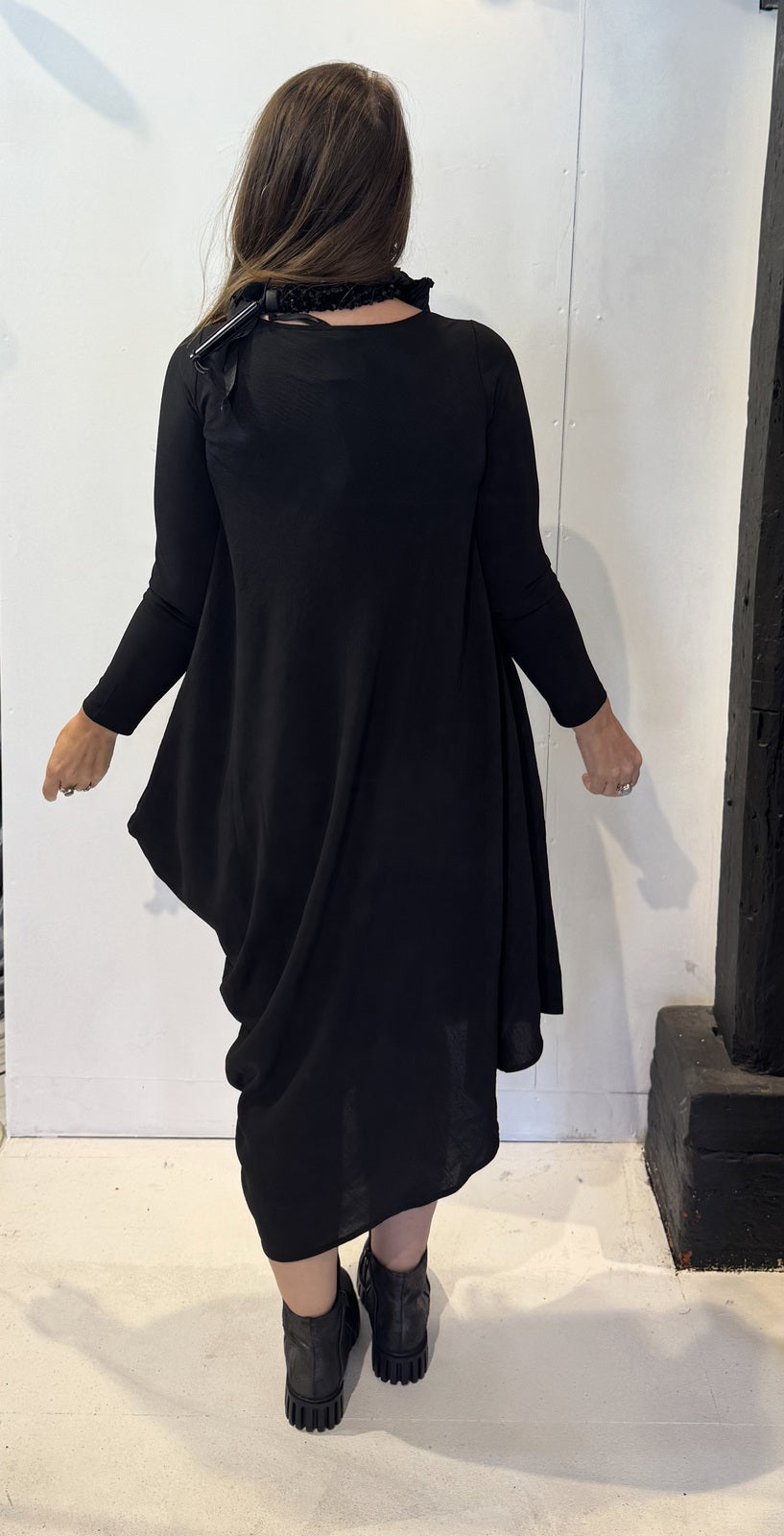 Back view of the Strelizia black dress showing its uneven hem