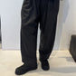 Front view of the Igor Dobranic Ivy dark grey trousers showing their rounded legs and side pockets