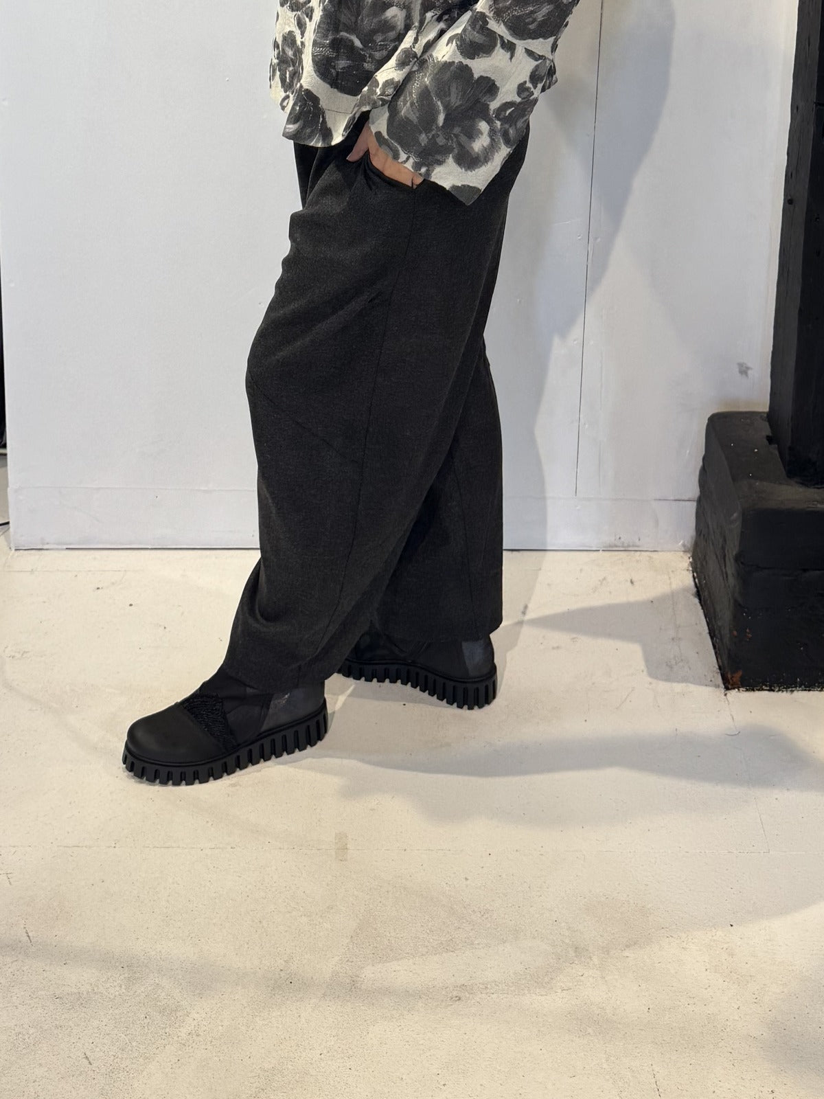 Side view of the Ivy trousers showing their sculptural shape and ankle-length hem