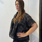 Side view of the Lotus waistcoat showing its extended shoulder and short silhouette