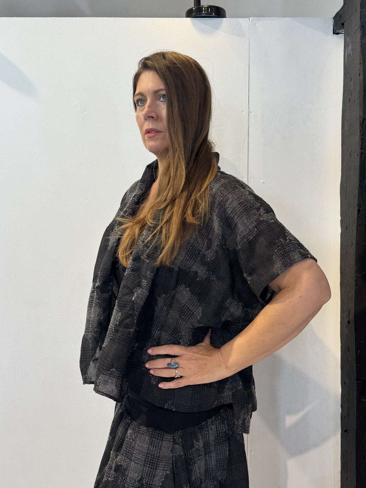 Side view of the Lotus waistcoat showing its extended shoulder and short silhouette