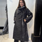 Igor Dobranic Magnolia coat buttoned up, with its large collar wrapped around the neckline
