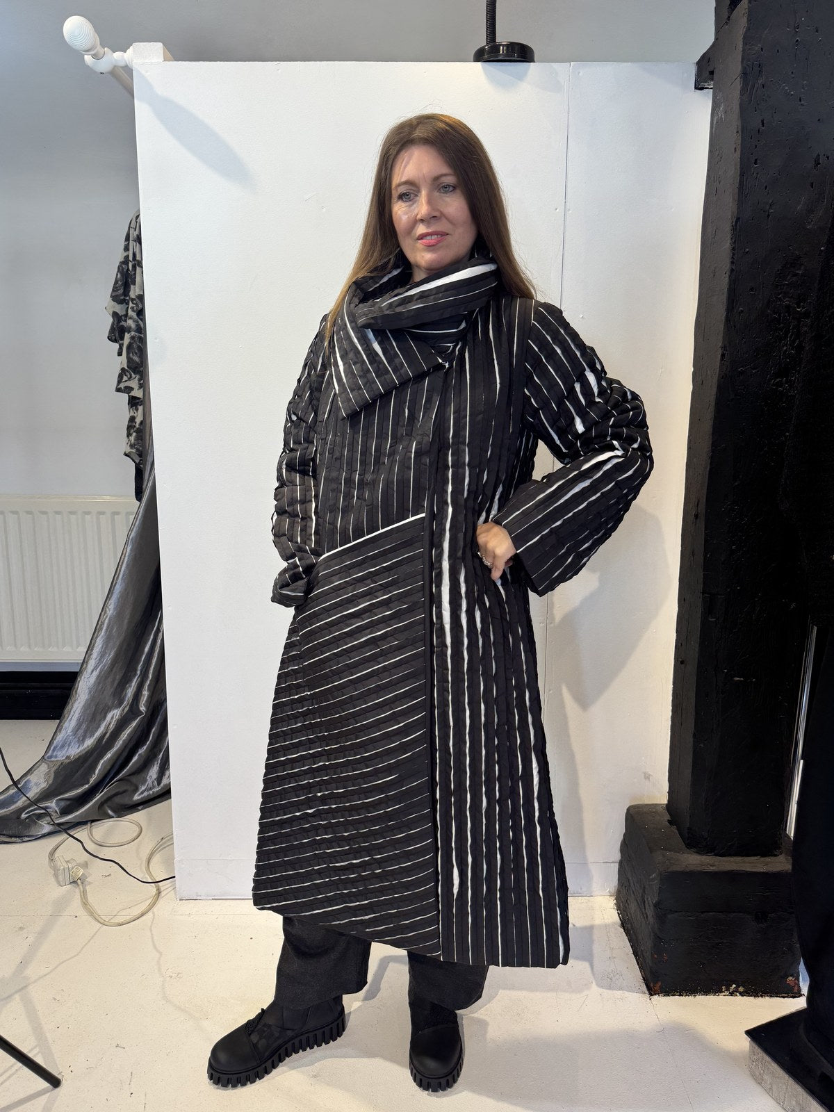 Igor Dobranic Magnolia coat buttoned up, with its large collar wrapped around the neckline