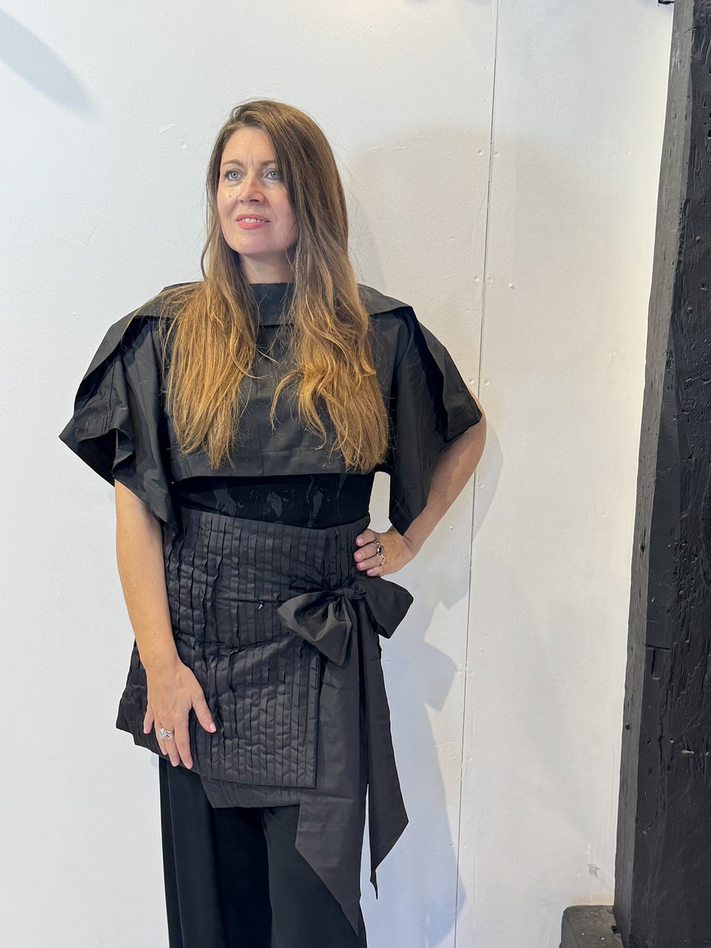 Front view of the Igor Dobranic May black bolero showing its cropped body and folded shoulder panels