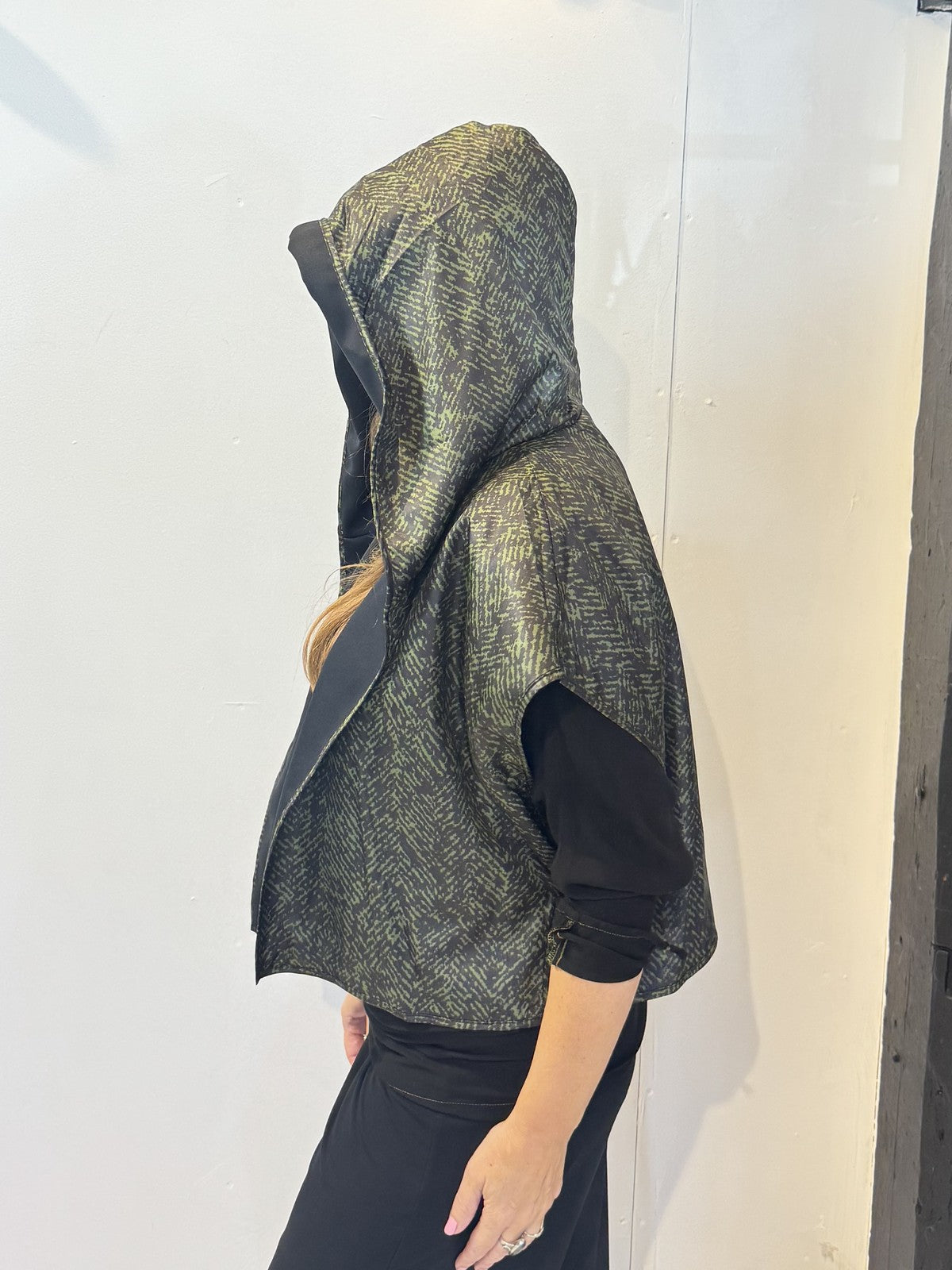 Side view of the Pensy waistcoat showing its patterned side and raised hood