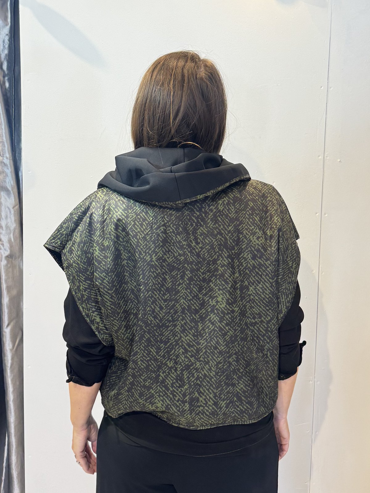 Back view of the Pensy waistcoat showing its green pattern with the hood down