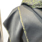Close-up of the Pensy waistcoat showing its plain black fabric and green patterned seam edging