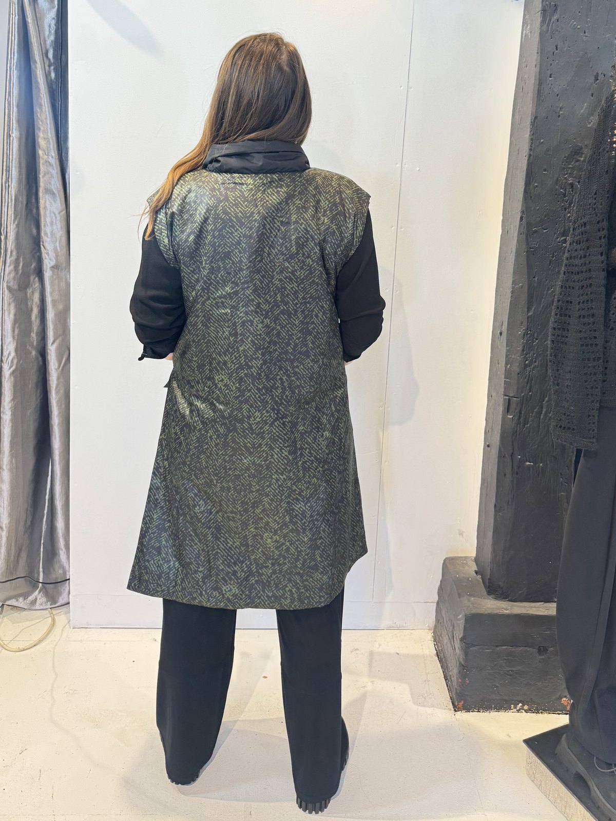 Back view of the Rue waistcoat showing the abstract green pattern and extended shoulders