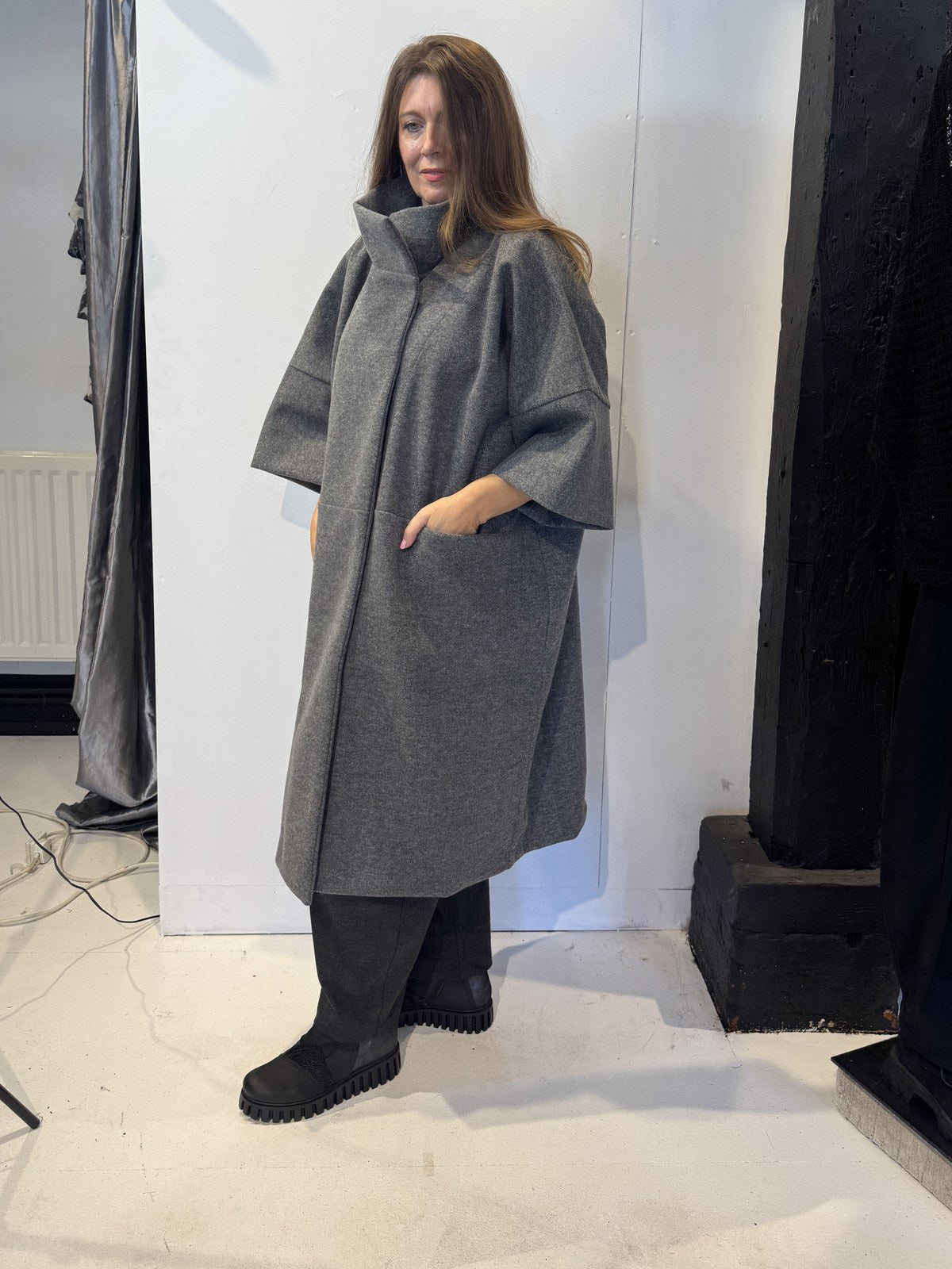 Three-quarter side view of the Sorrel grey coat with wide cropped sleeves