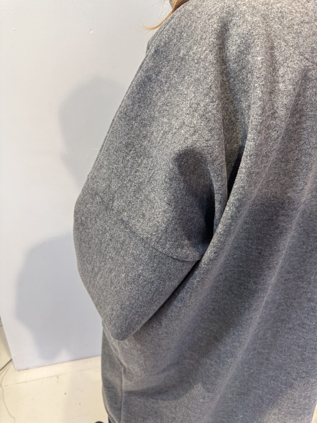 Close-up of the Sorrel coat showing its curved patch pocket and mottled grey texture