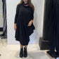 Front view of the Igor Dobranic Strelizia black dress showing its draped asymmetric hem