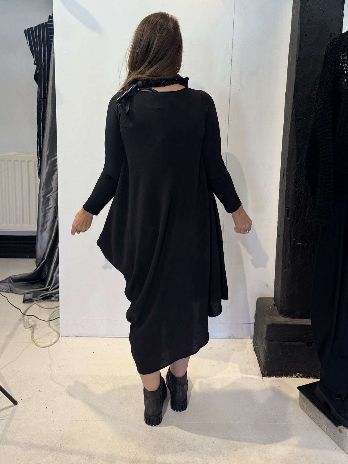 Back view of the Strelizia black dress showing its uneven hem