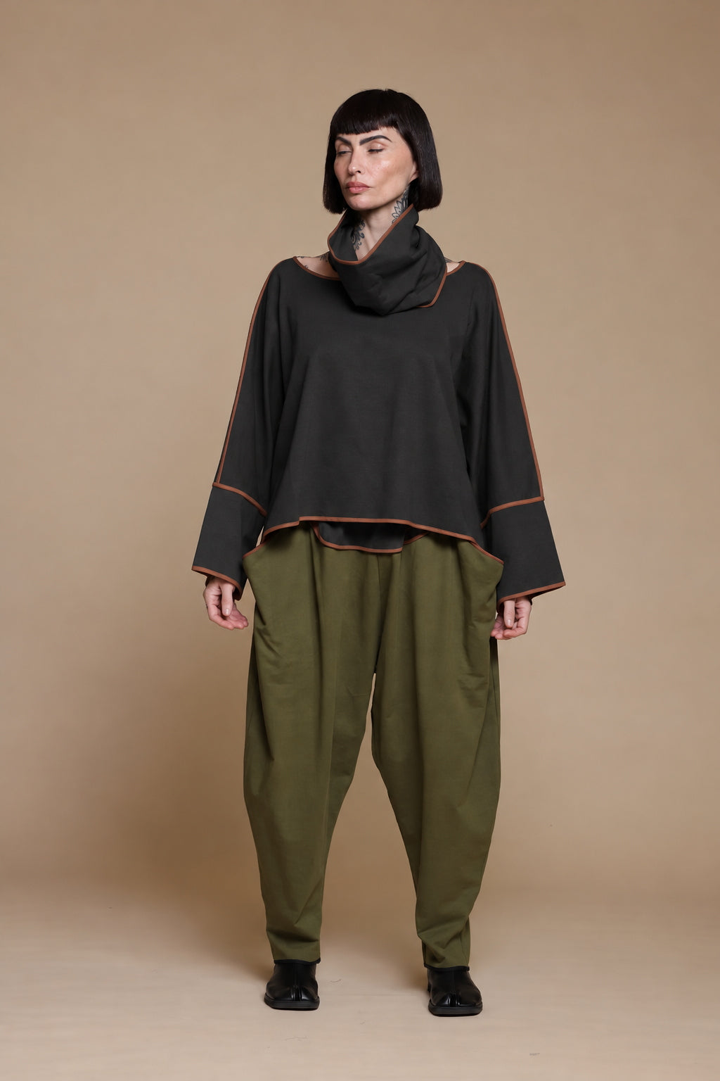 Black Kedem Sasson draped top with warm contrast edging, full front view