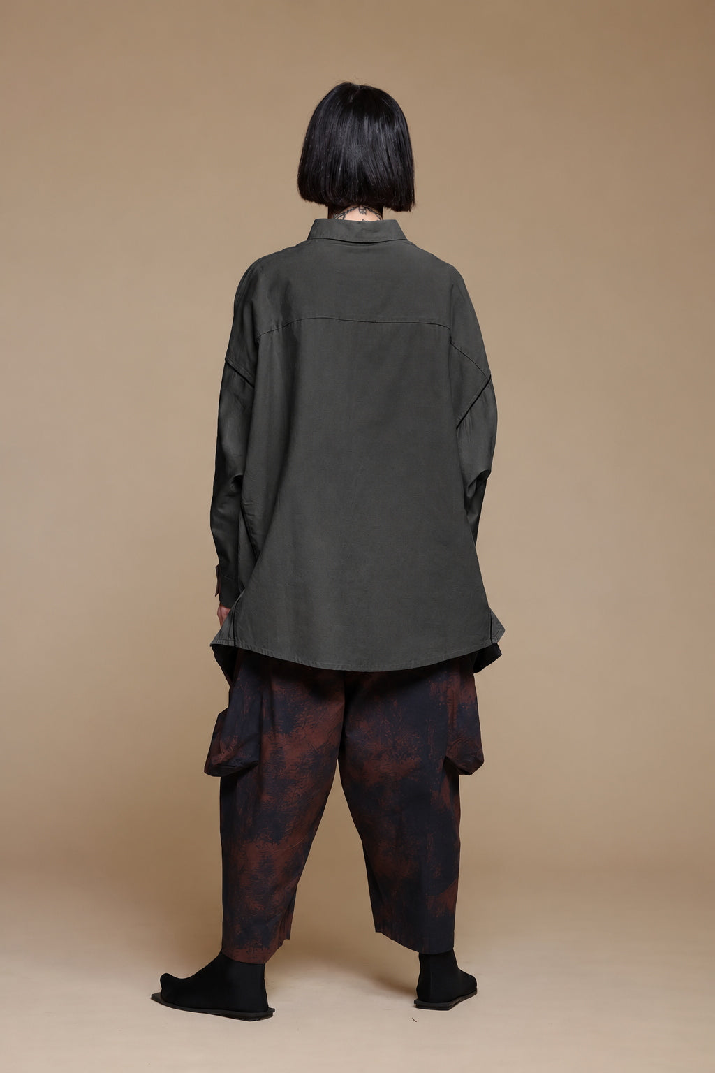 Black cotton pocket shirt, back view showing the curved hem