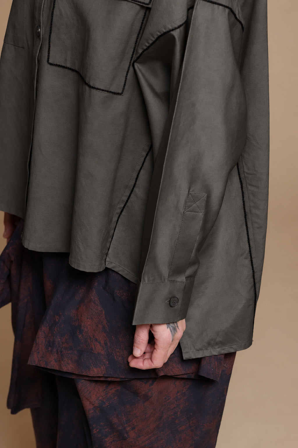 Black cotton shirt, detail of the chest pocket, sleeve cuff and buttons