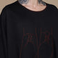 Black top, close-up of the neckline and shoe artwork