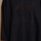 Black top, detail of the shoe artwork and contrast-trimmed hem