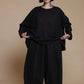 Black shoe-artwork top, front view with the hem held out to show its width