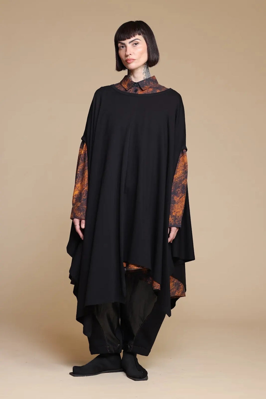 Black draped top layered over a separate printed shirt